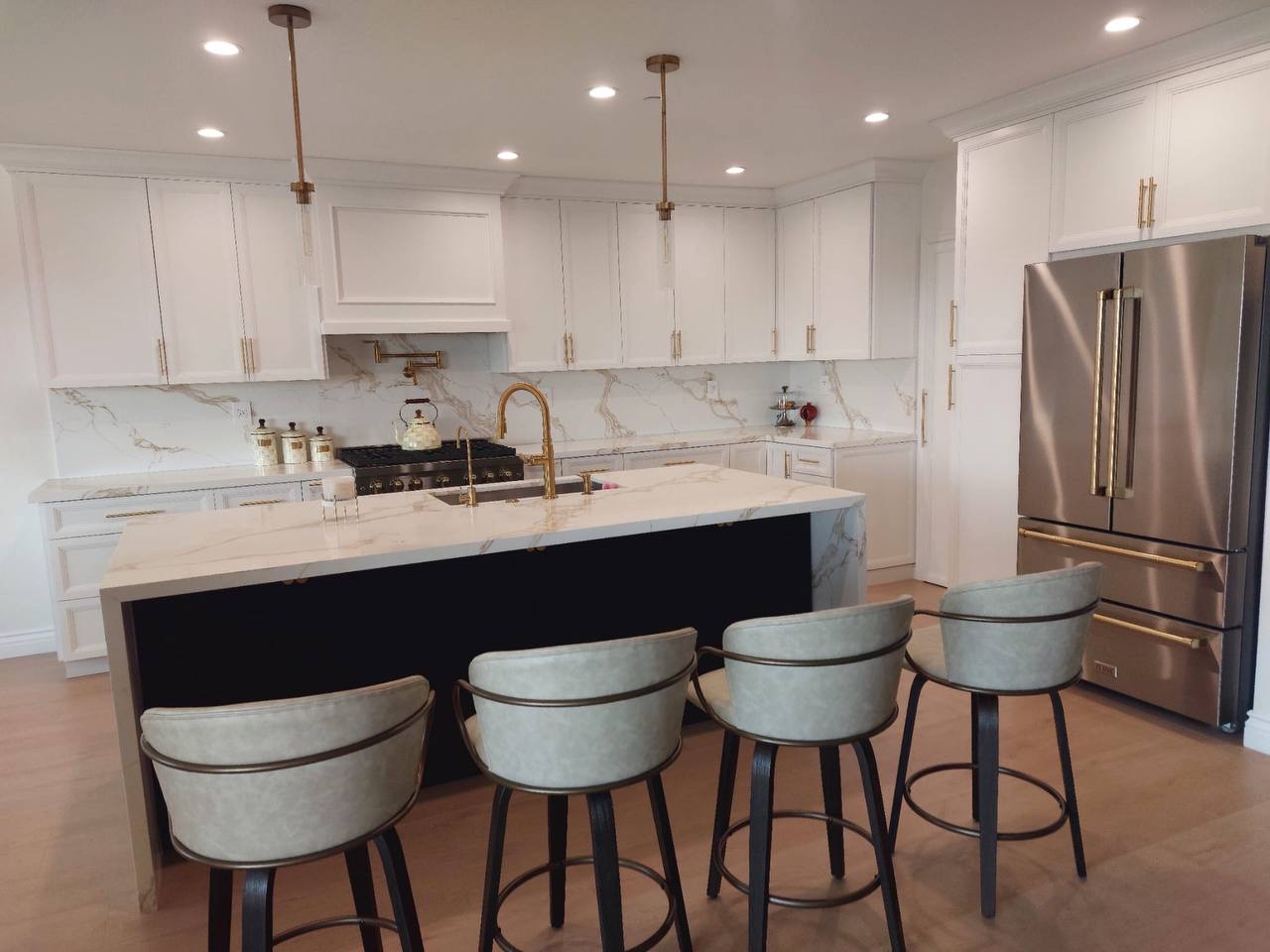 Custom white shaker kitchen with calacatta quartz island, brass pendants and panel-ready fridge in Glendale CA