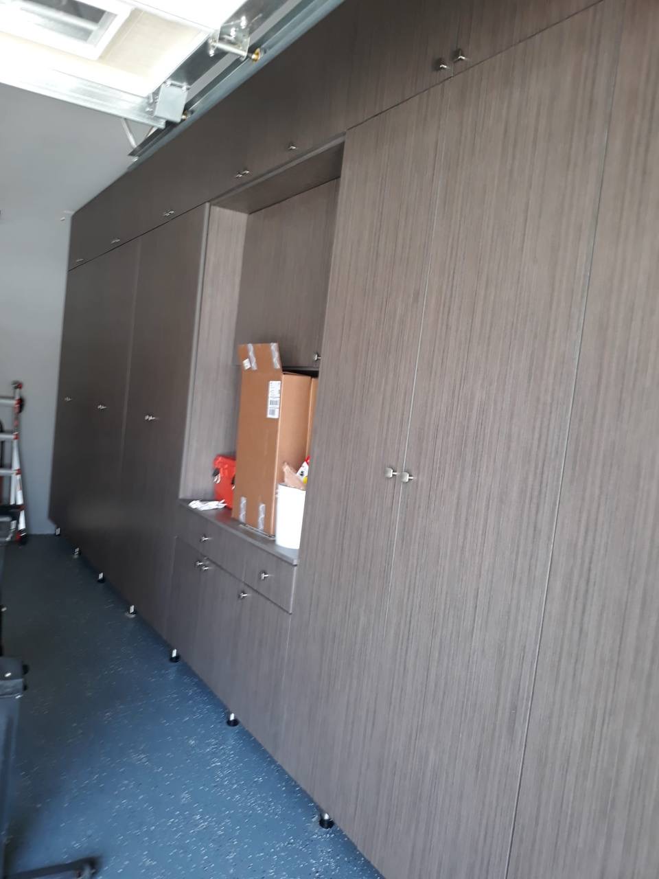 Custom full garage cabinetry wall with workbench niche and overhead storage in Glendale CA