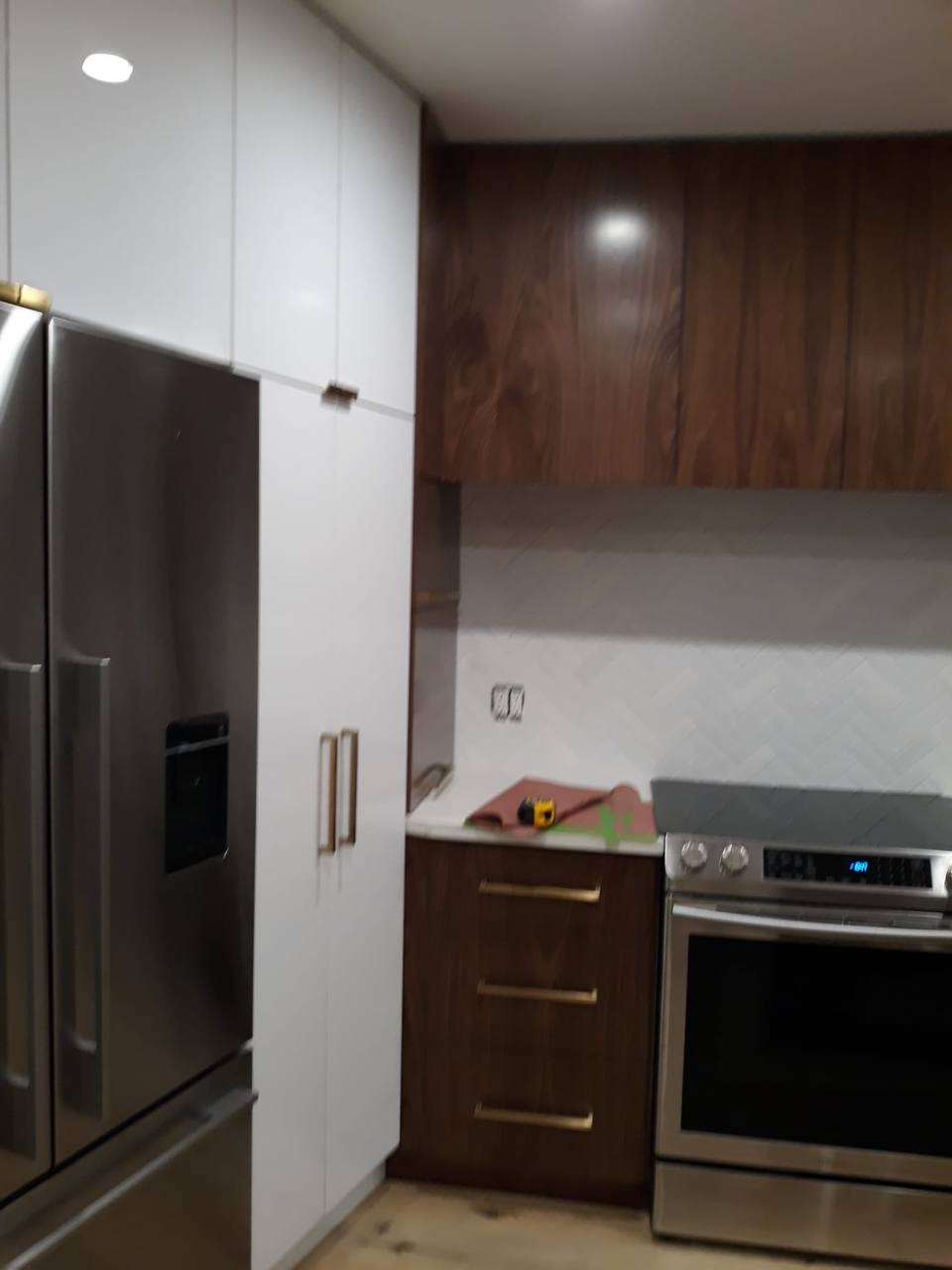 Custom two-tone kitchen with walnut upper cabinets and white floor-to-ceiling pantry tower in Glendale CA