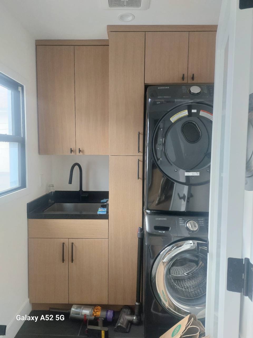 Custom white oak laundry room cabinetry with utility sink and tall storage tower in a Glendale CA home
