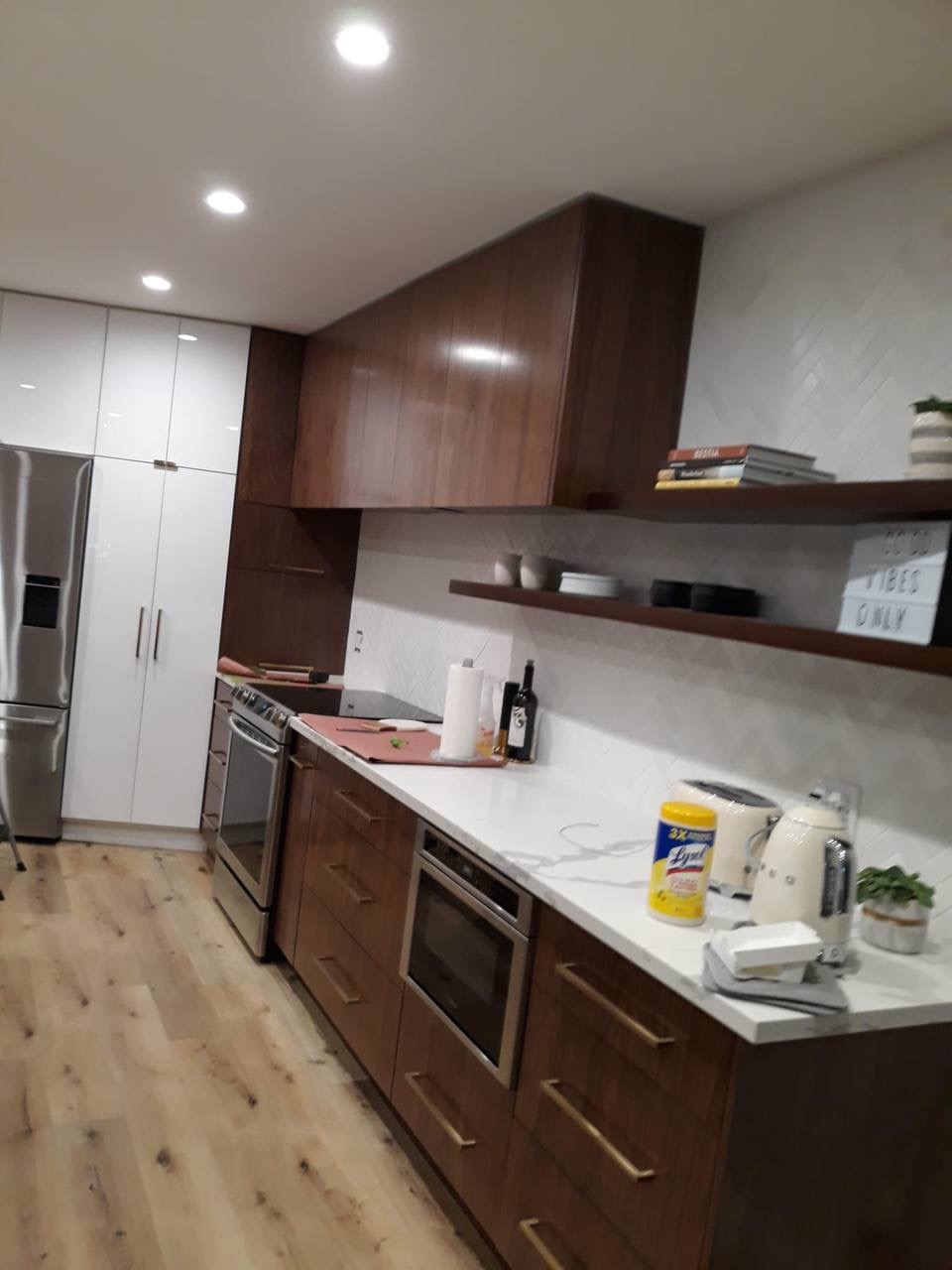 Custom walnut galley kitchen with white pantry tower and floating walnut shelves in Glendale CA