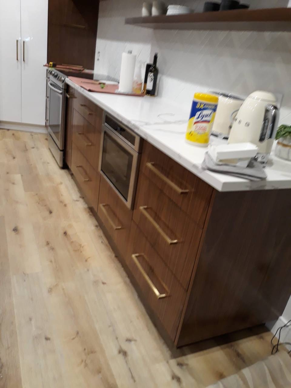 Custom walnut kitchen drawer bank with built-in microwave drawer and brass pulls in Glendale CA
