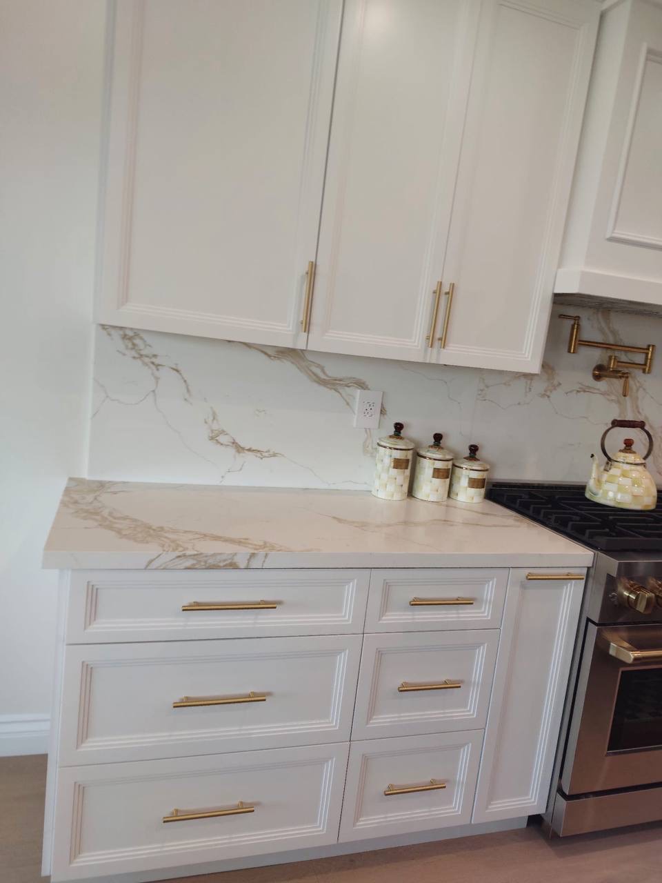 Custom white kitchen drawer bank with picture-frame moulding, brass pulls and calacatta quartz counter in Glendale CA