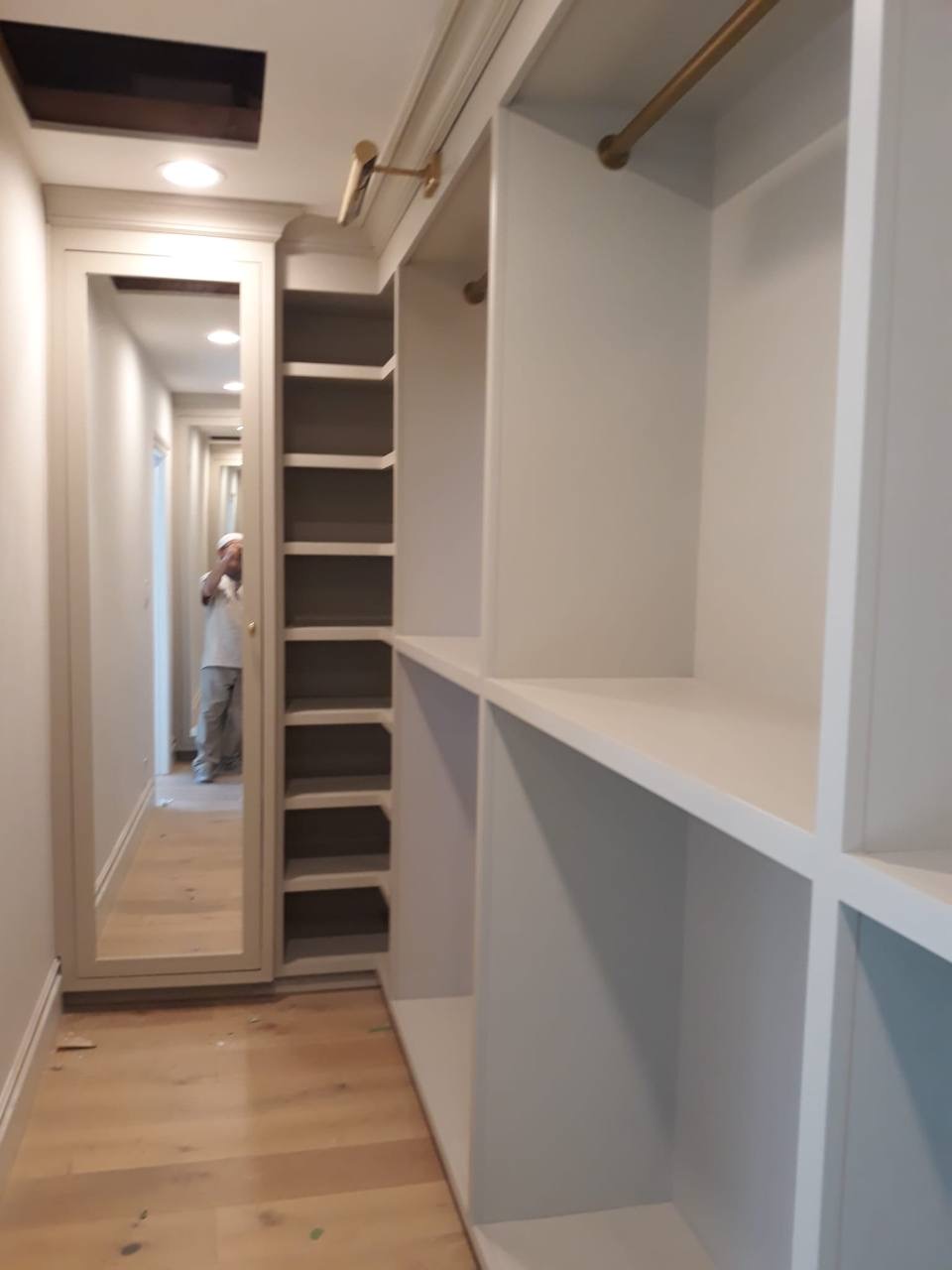 Custom walk-in closet with stepped shoe shelves and brass hanging rods in Glendale CA