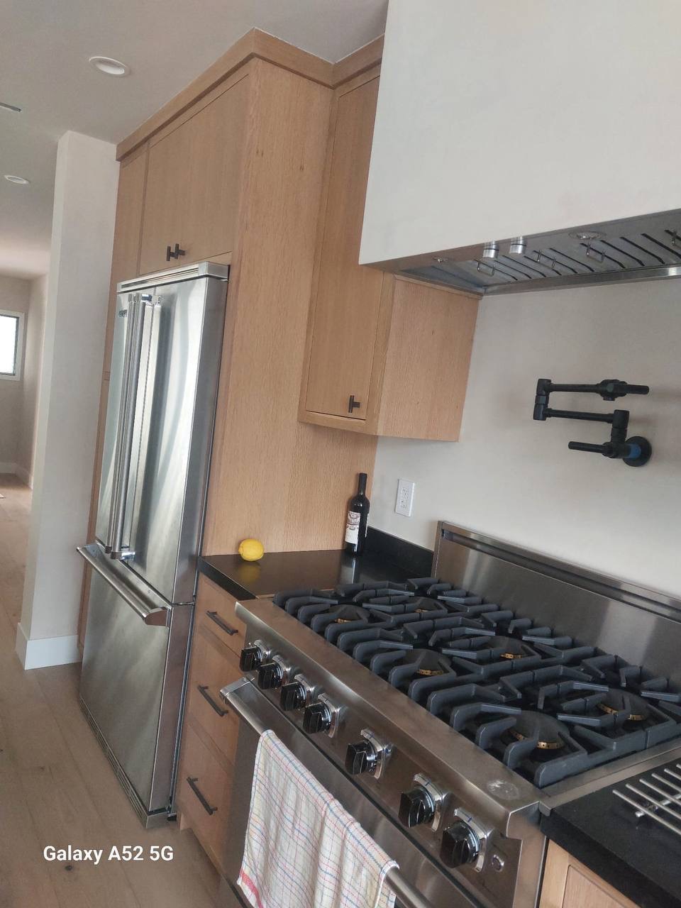 Custom white oak kitchen cabinetry surrounding a pro range and integrated refrigerator in Glendale CA