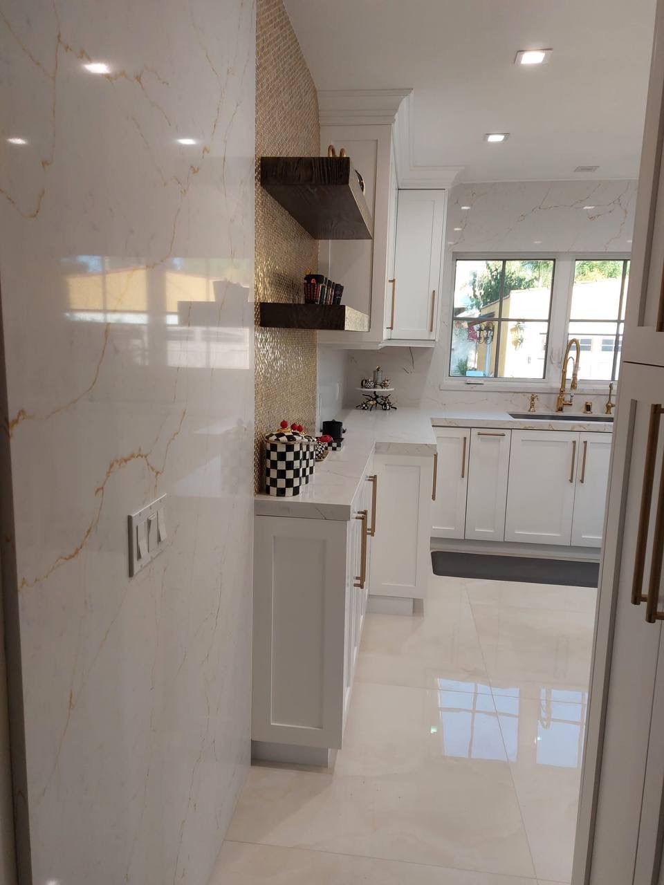 Custom white shaker kitchen cabinets with gold-veined quartz counters and brass hardware in Glendale CA