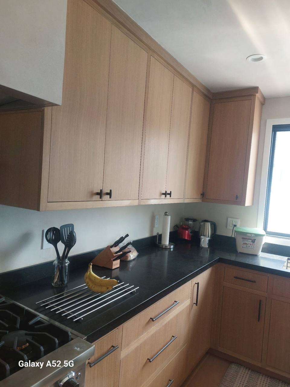 Custom rift-sawn white oak slab kitchen cabinets with honed black stone counters in a Glendale CA home