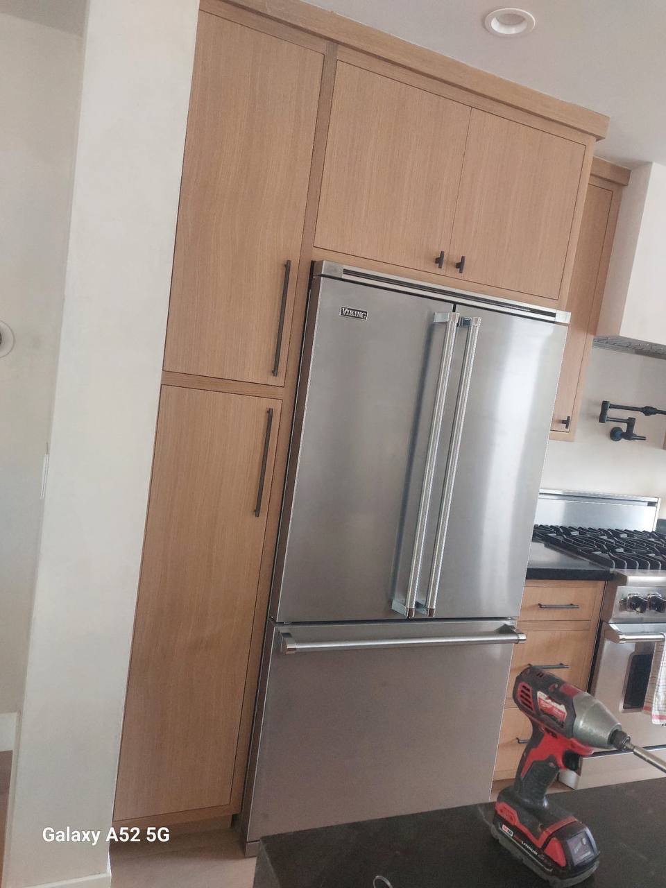 Custom white oak tall pantry cabinets with integrated Viking refrigerator panels in a Glendale CA kitchen