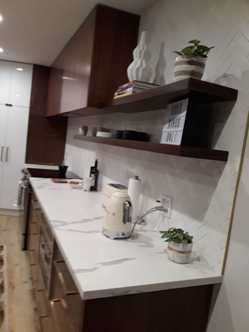Custom walnut kitchen cabinetry with floating shelves over marble counter in Glendale CA
