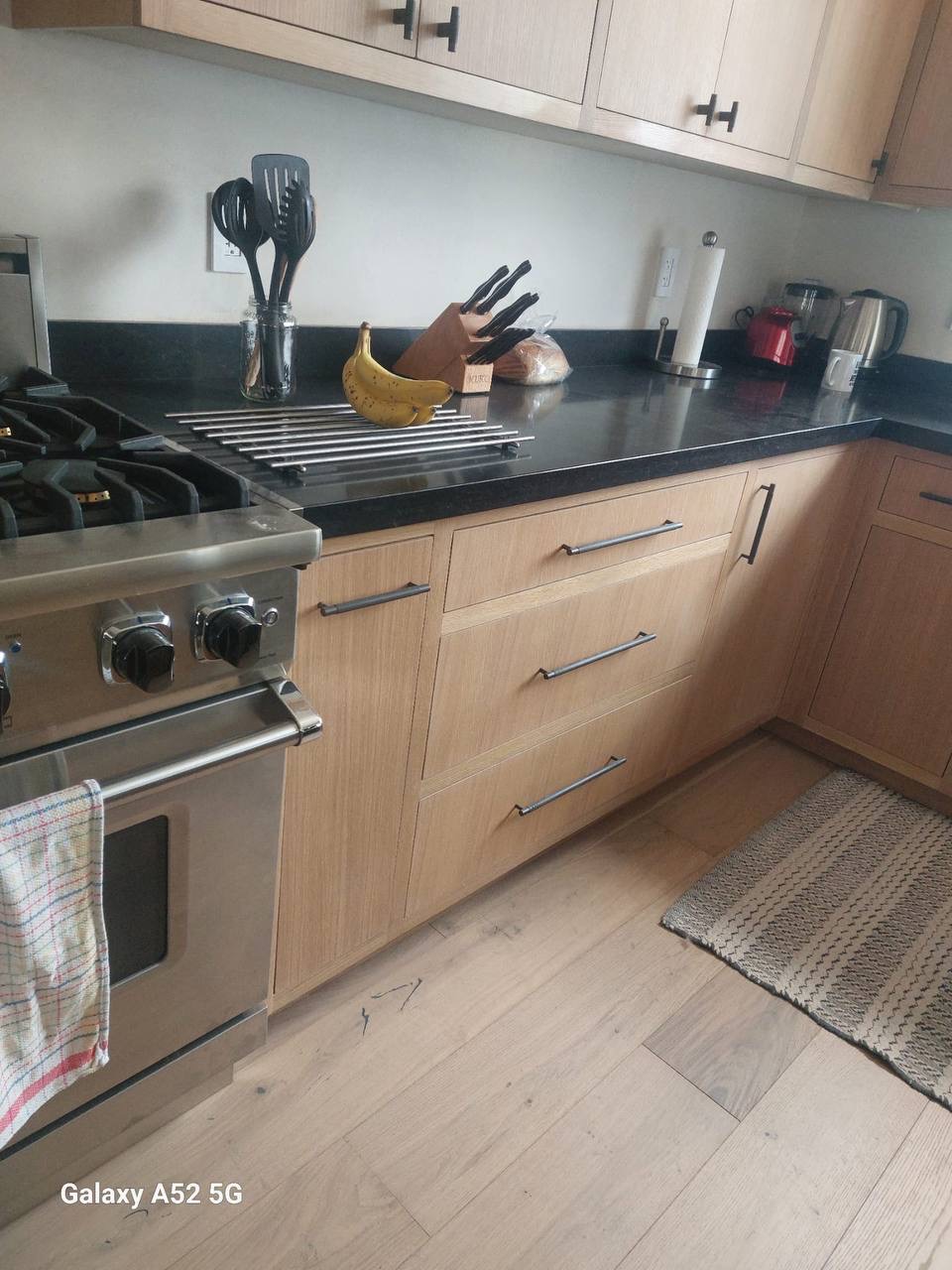 Custom white oak shaker kitchen base cabinets and drawer banks around a pro gas range in Glendale CA