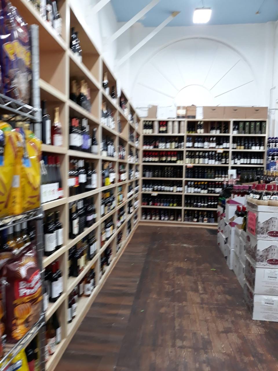 Custom wood wine shop shelving with bottle cubbies built by JH Cabinetry for a Los Angeles area retailer