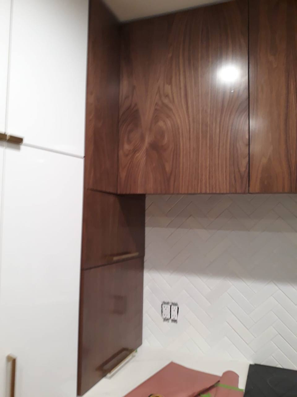 Custom two-tone walnut and white kitchen cabinets with herringbone tile backsplash in Glendale CA