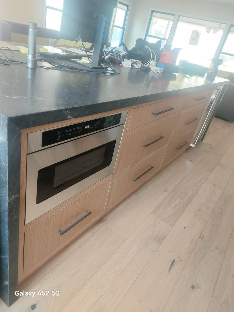 Long custom white oak kitchen island with soapstone counter and built-in microwave drawer in Glendale CA