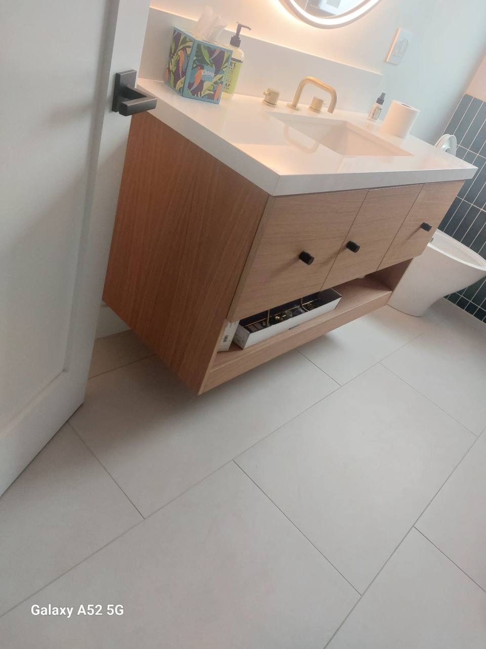 Custom floating white oak bathroom vanity with open lower shelf and matte black hardware in Glendale CA